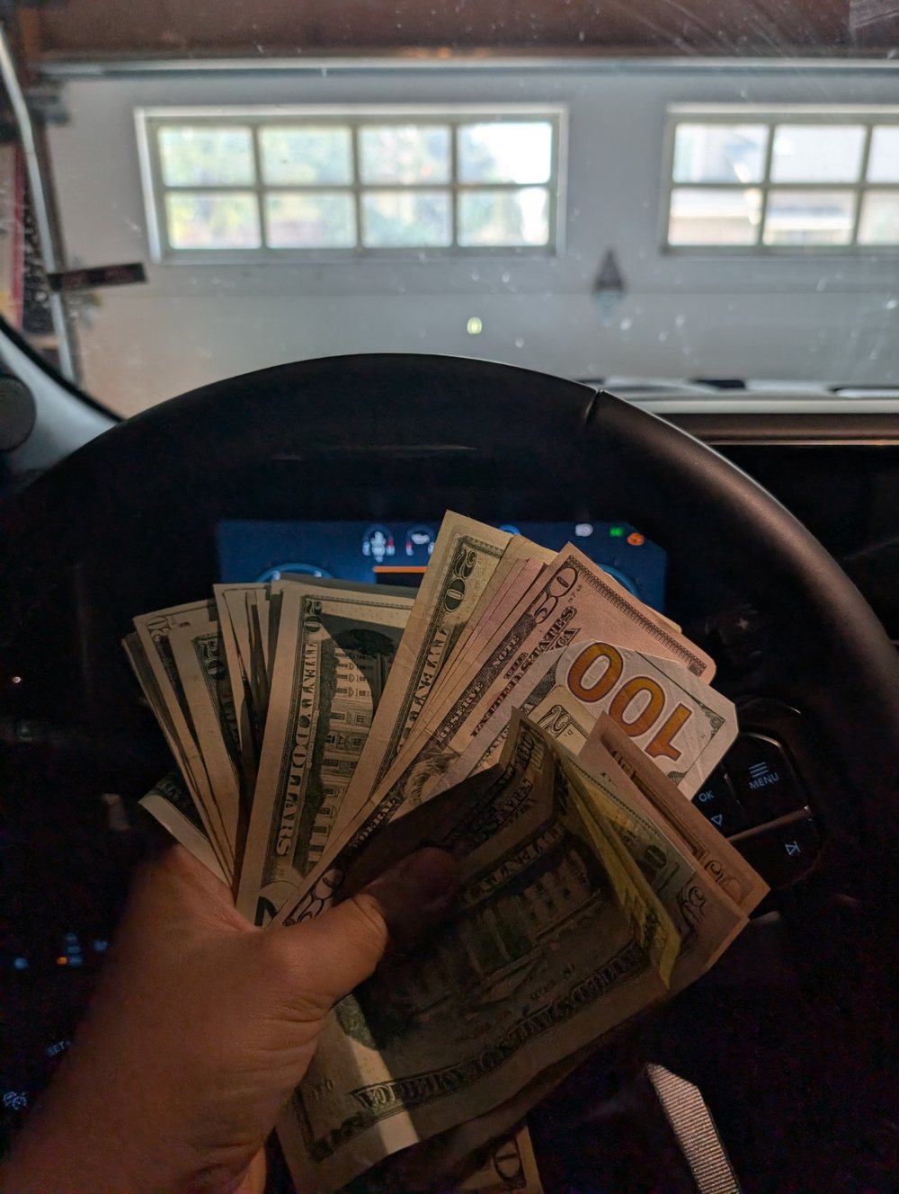 Personal behind-the-scenes photo with cash inside a vehicle