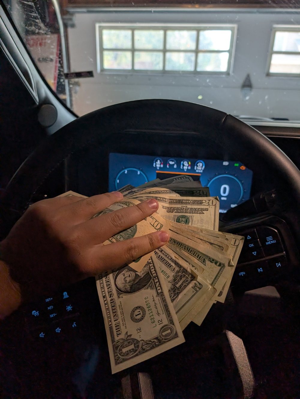 Personal behind-the-scenes photo with cash inside a vehicle