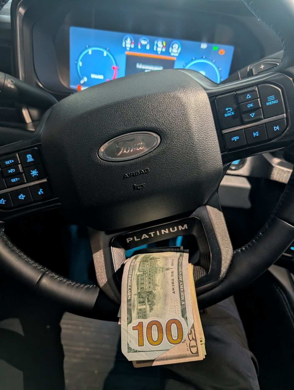 Personal behind-the-scenes photo showing cash and a Ford Platinum steering wheel